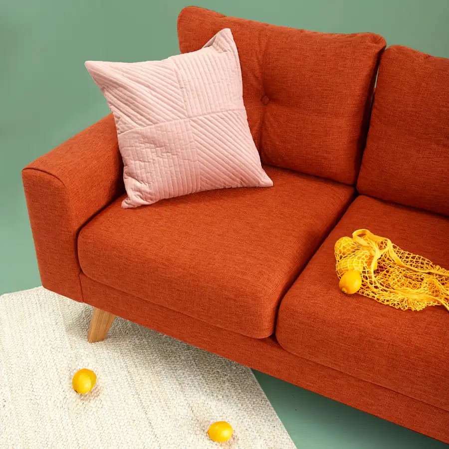 Warm living room with a rust-orange sofa, the kind of interior home-design simulations let you rebuild