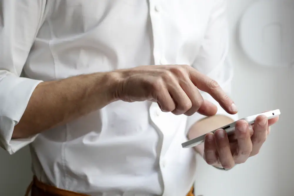 Hands holding a smartphone and tapping the screen during a review session